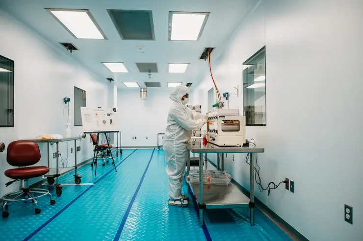 Cleanroom technician working with advanced biomanufacturing equipment