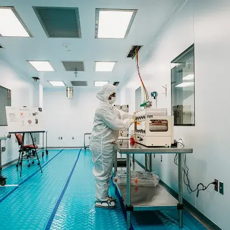 Cleanroom technician working with advanced biomanufacturing equipment